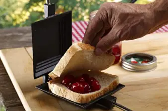 Sandwich iron cooking a cherry pie.