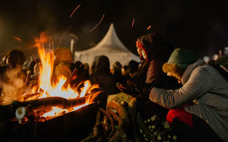 A group of campers sitting around a campfire, enjoying the fall foliage and night sky. Affordable Fall Camping Getaways