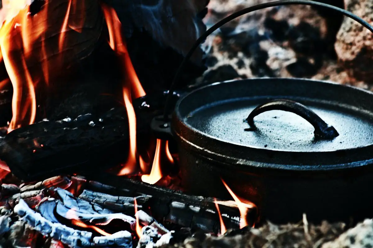 A Dutch oven with food cooking inside it, showcasing its versatility and rustic charm. Potatoes in a Dutch Oven