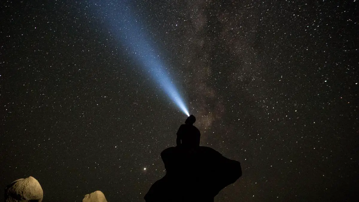 Image depicting a person hiking at night with a headlamp illuminated, showcasing the importance of choosing the right headlamp for hiking. Hiking Headlamps